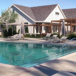 resort style pool with seating trees and a building behind it
